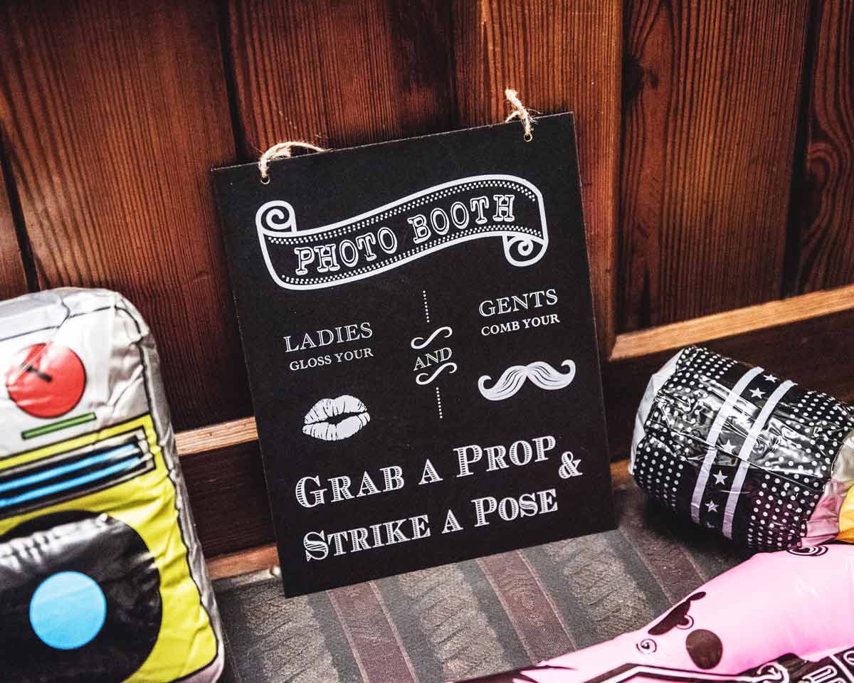 Photo-Booth-Schild mit Accessoire-Kiste voller Verkleidungen